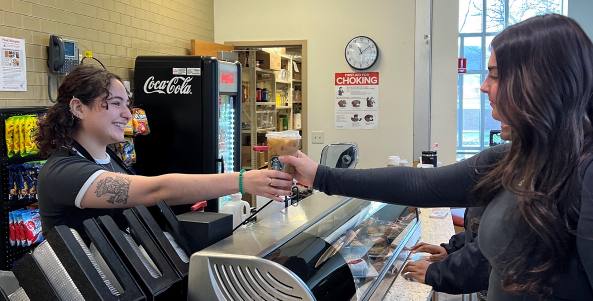 Cashier handing coffee to customer