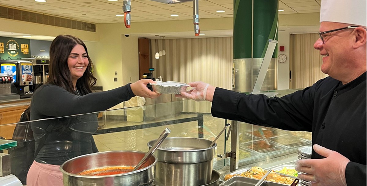 Chef handing food to student